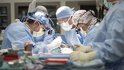 Several doctors performing a cardiac surgery in an operating room.