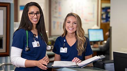 Two female caregivers smiling.